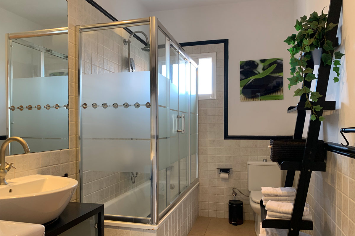 Baño moderno en el apartamento Freedom, con ducha cerrada y detalles decorativos.