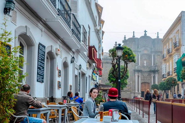 Terrazas en el casco histórico de Tarifa con vistas a edificios antiguos.