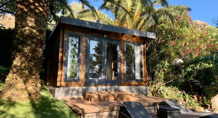 Caseta de madera en la Villa Nepal rodeada de vegetación tropical con un diseño rústico y acogedor.
