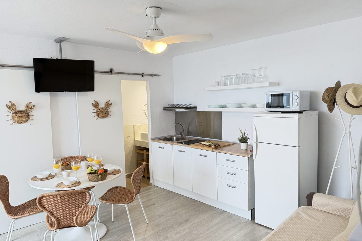 Cocina abierta y comedor con mesa redonda en apartamento turístico moderno Infinity en Tarifa.