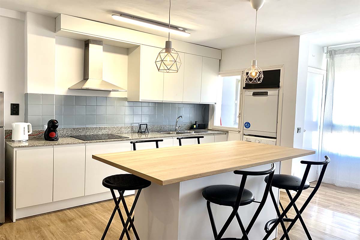 Vista frontal de una cocina moderna con electrodomésticos y detalles minimalistas.