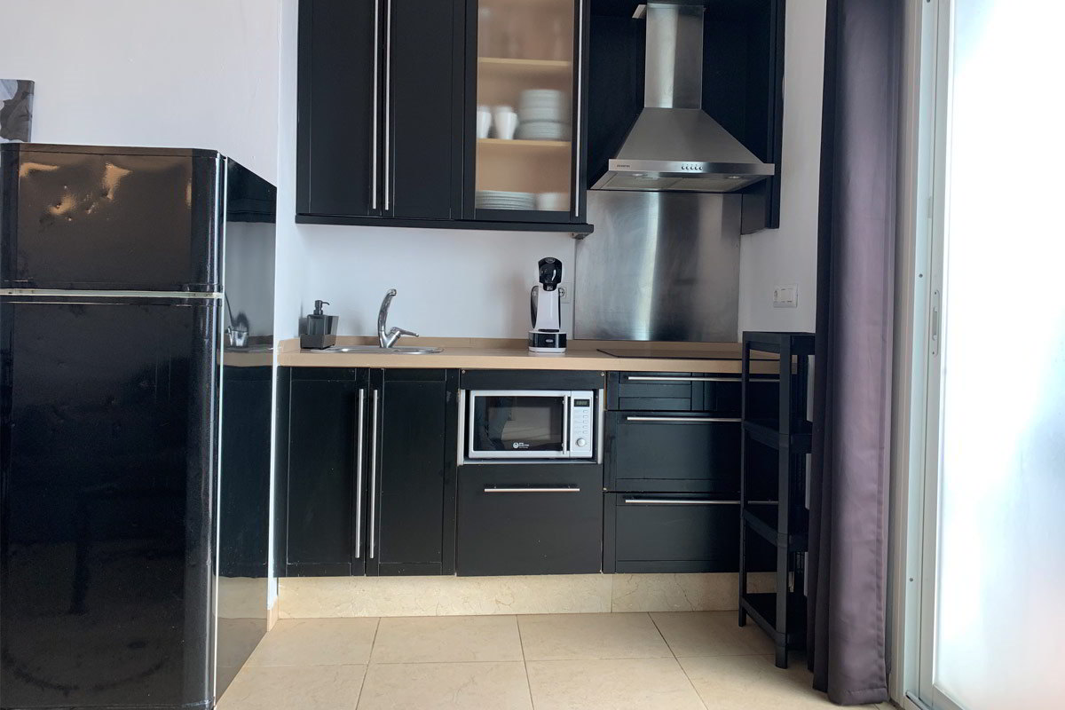 Cocina moderna en el apartamento Freedom, con electrodomésticos y muebles en negro.