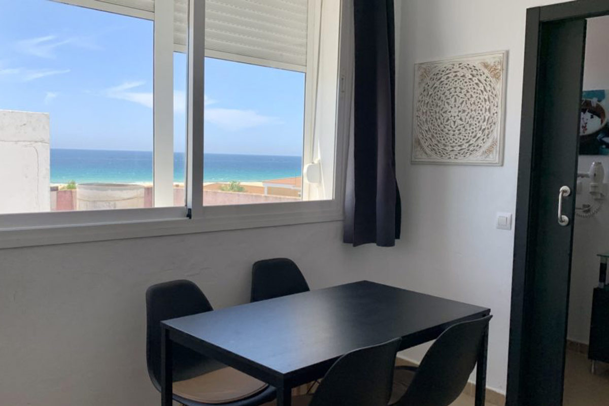 Comedor del Estudio Senses con mesa negra y vistas al mar.