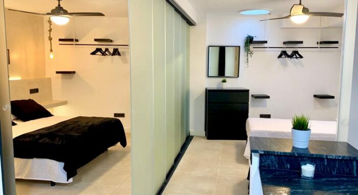 Dormitorio del apartamento Las Gaviotas con cama doble y espacio abierto para otra cama, decoración minimalista y moderna.