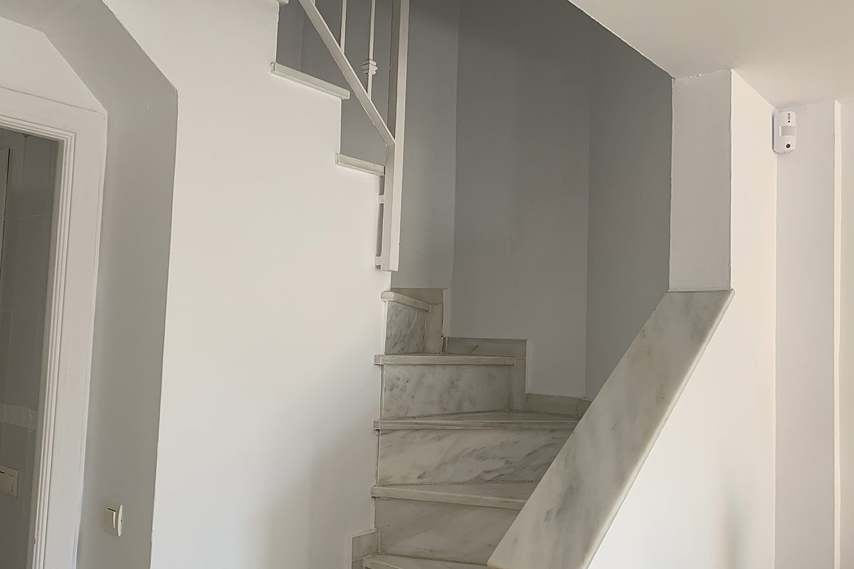 Armario empotrado en el dormitorio de Los Lances 2, con diseño blanco y paneles de mimbre, decorado con detalles naturales.