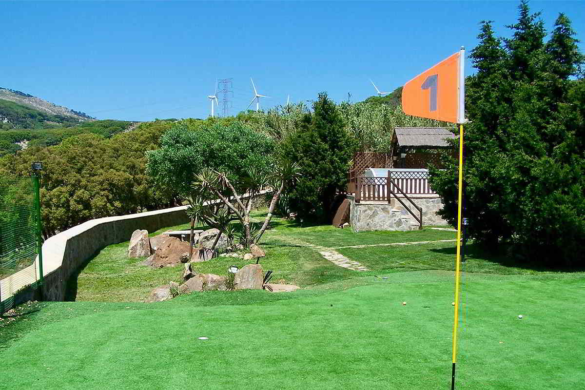 Zona de minigolf en los jardines de Villa Paraíso, en el chalet La Ahumada, rodeada de árboles y con vistas a la montaña y los molinos de viento.
