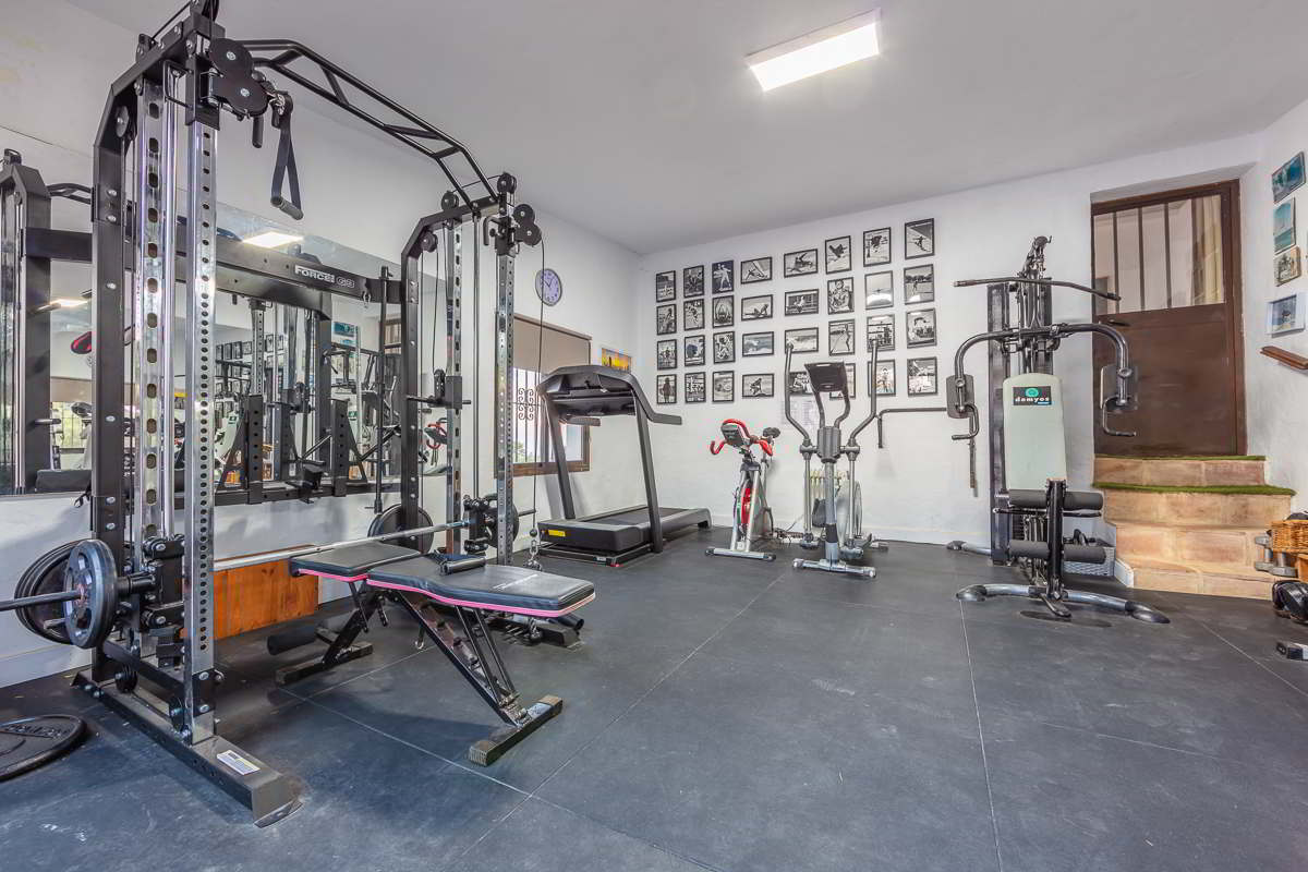 Gimnasio privado de Villa Paraíso con máquinas de musculación y cardio en Villas La Ahumada, Tarifa.