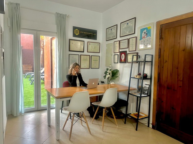 Oficina de Leticia del Valle en Tarifa, equipada con mesa de trabajo, diplomas en la pared y salida al jardín.