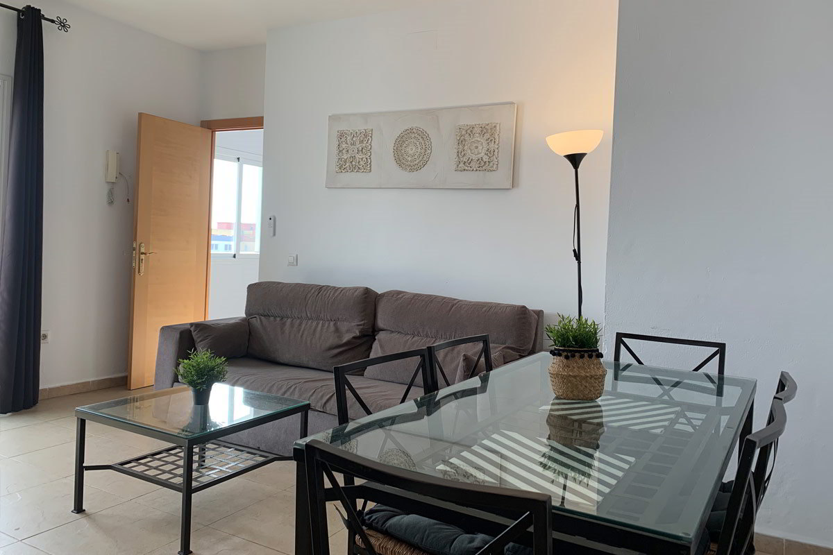 Sala de estar luminosa en el apartamento Freedom, con sofá y mesa de cristal.