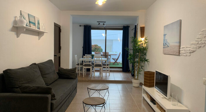 Salón en la Urbanización Las Cañas con decoración moderna, sofá cómodo, mesa de comedor y acceso a la terraza.