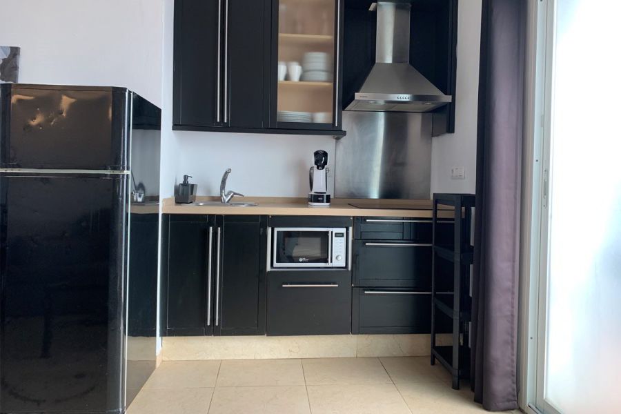 Cocina moderna en el apartamento Freedom, con electrodomésticos y muebles en negro.