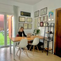 Oficina de Leticia del Valle en Tarifa, equipada con mesa de trabajo, diplomas en la pared y salida al jardín.