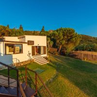 Fachada de Villa Paraíso con jardín y escaleras exteriores en Villas La Ahumada, Tarifa.