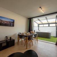 Salón comedor del apartamento Las Gaviotas 9B en Tarifa con mesa de comedor y vistas directas al patio con jacuzzi privado.