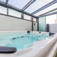 Jacuzzi privado del apartamento Las Gaviotas 9B en Tarifa en patio cubierto con barbacoa exterior y cerramiento acristalado.