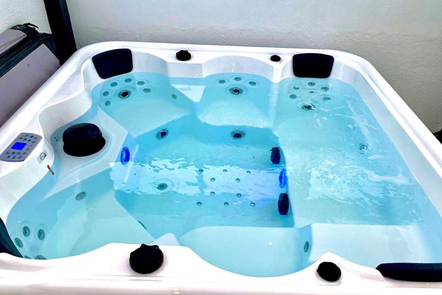 Primer plano del jacuzzi encendido con chorros de agua, en terraza privada.