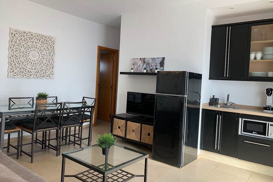 Cocina y comedor del apartamento Freedom, combinando muebles modernos negros y electrodomésticos.