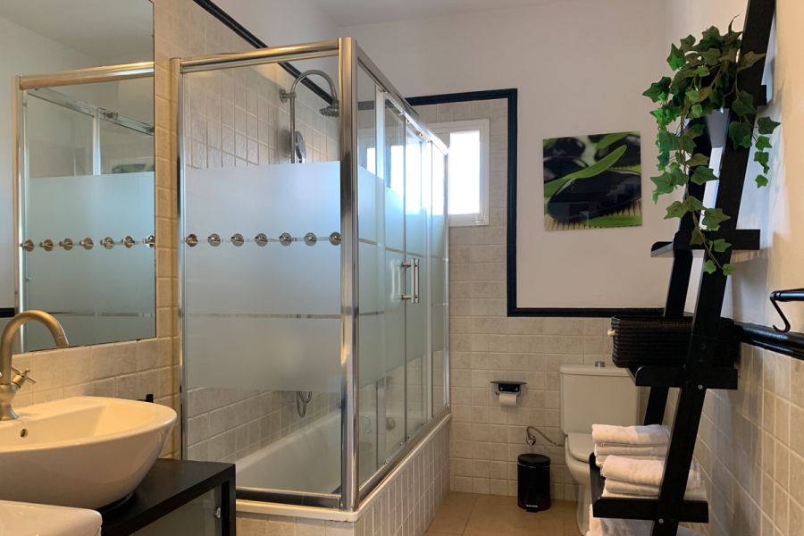 Baño moderno en el apartamento Freedom, con ducha cerrada y detalles decorativos.