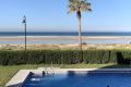 Piscina frente a la playa en Los Lances 2, con vistas al mar y una palmera en primer plano
