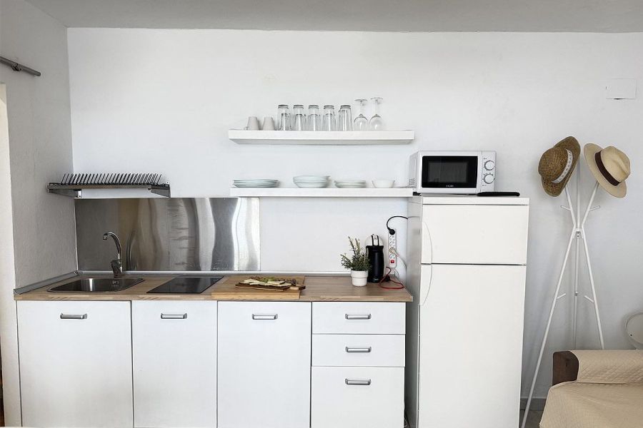 Cocina lineal equipada del apartamento Infinity con electrodomésticos y menaje en Tarifa.