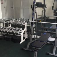 Zona de entrenamiento del gimnasio del Edificio Senses con pesas y equipo de musculación.