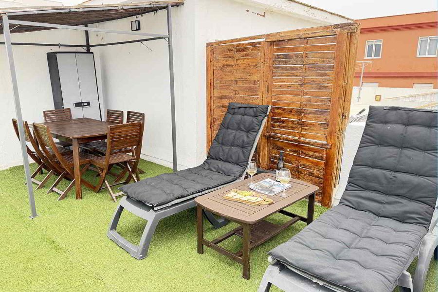 Terraza privada con tumbonas y mesa exterior en apartamento Infinity en Tarifa.