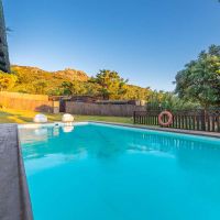 Piscina de Villa Paraíso con vistas a la montaña y zona ajardinada en Villas La Ahumada, Tarifa.