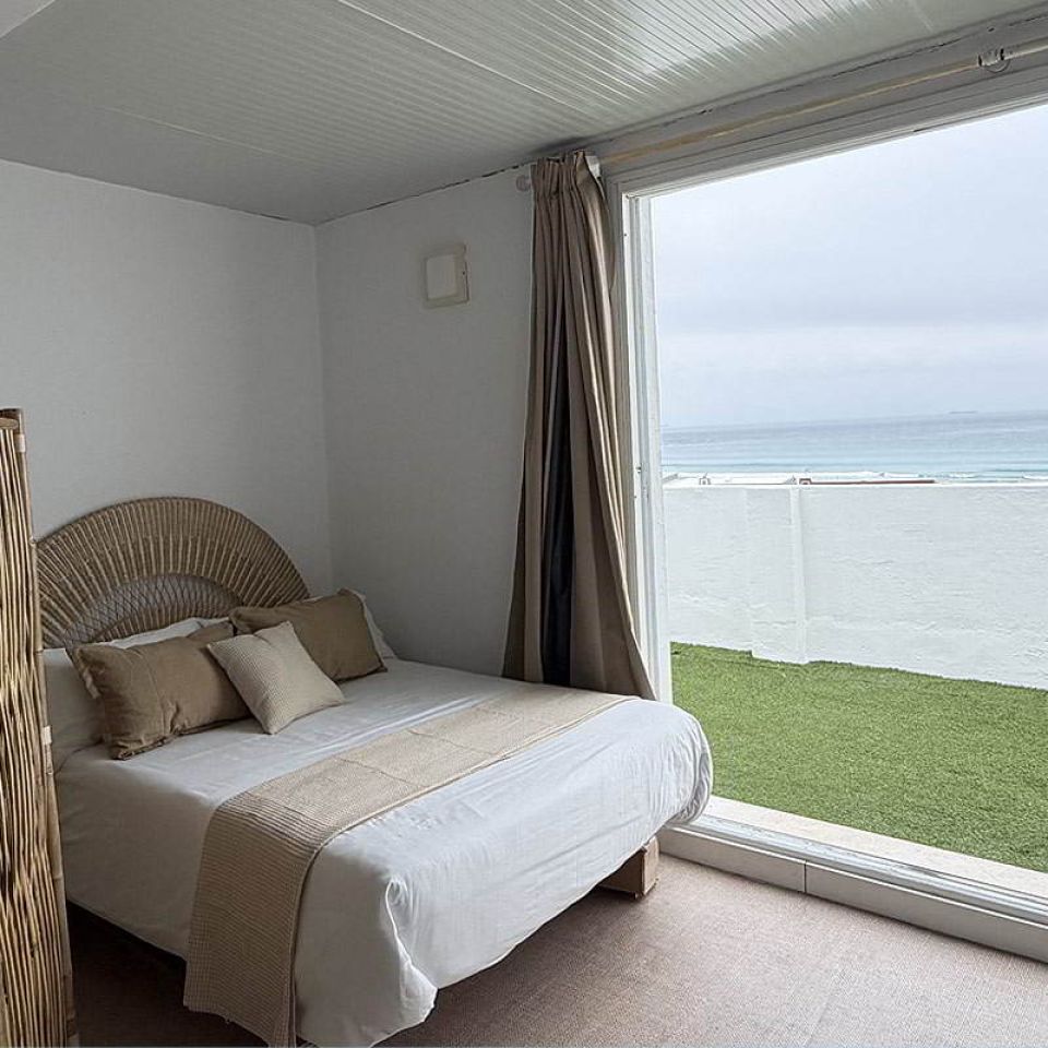 Dormitorio con cama doble y vistas al mar desde el apartamento Infinity en Tarifa.