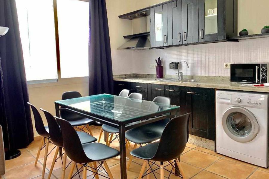 Cocina totalmente equipada del apartamento Wellness con mesa de comedor y mobiliario moderno.