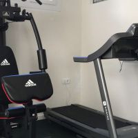 Equipo de entrenamiento con máquinas de fuerza y cinta de correr en el gimnasio del Edificio Senses.