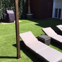 Zona ajardinada privada del Edificio Senses con tumbonas y barbacoa.
