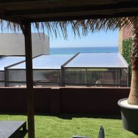 Terraza con césped artificial y vistas al mar en el Edificio Senses, rodeada de vegetación.